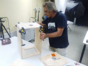 El fotógrafo en su estudio, construyendo la cámara minutera.